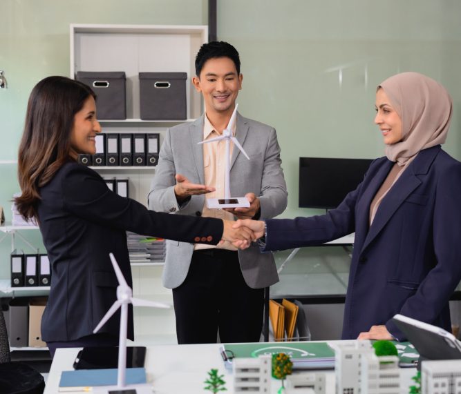 Businessmen shake hands after agreeing to start a new project successfully, renewable and sustainable development, and solar panel concept, happy working in modern office.